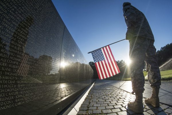A U.S. Army Reserve soldier reads some of the 58,307 names etched into The Wall of the Vietnam Veterans Memorial in Washington, D.C. as the sun rises July 22, 2015. (U.S. Army photo by Sgt. Ken Scar)